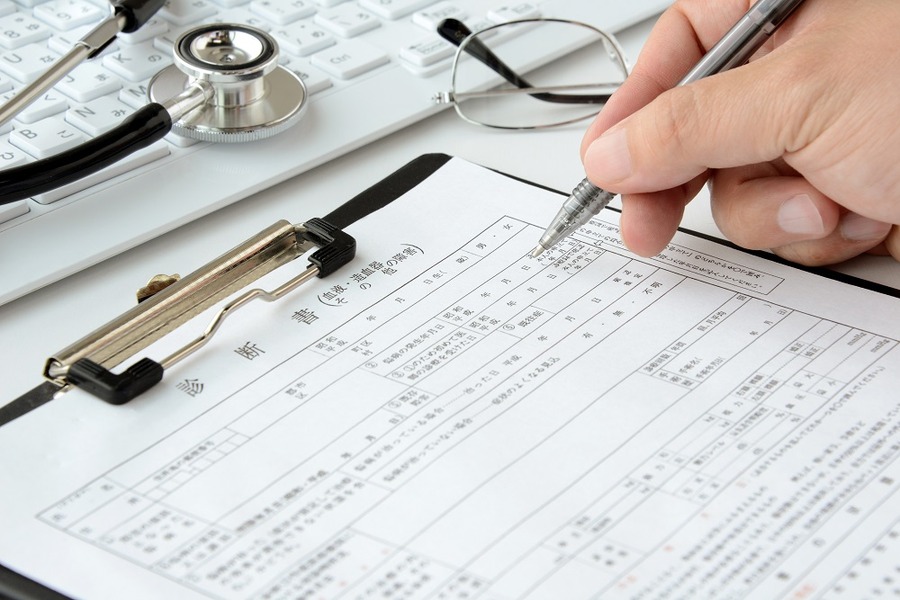 診断書を書こうとする医師