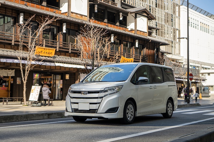 建物の前の道路を走る車 中程度の精度で自動的に生成された説明