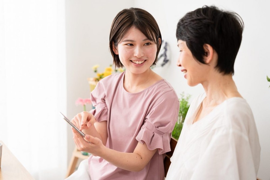 スマートフォンを使う母と娘