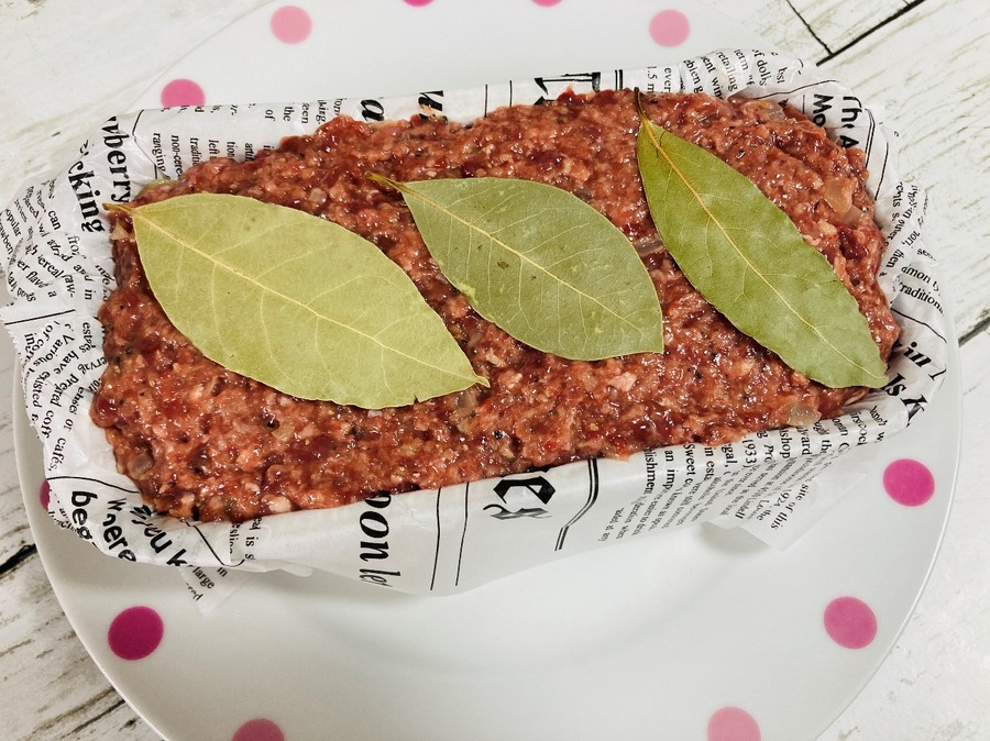 クッキングシートを敷いた型の中に肉ダネを詰めてローレルを3枚横並びに乗せます