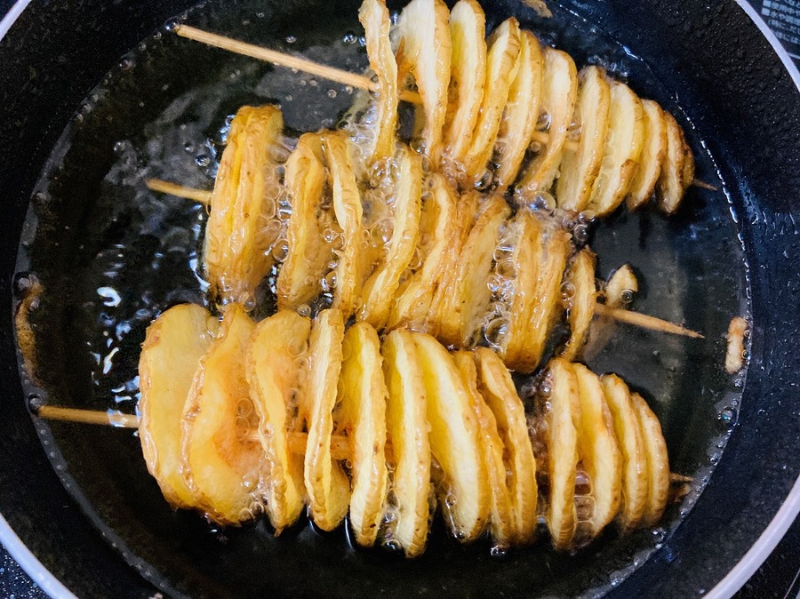 カットしたじゃがいもに竹串や割りばしを刺して、180度に熱した油でこんがりと揚げたら完成
