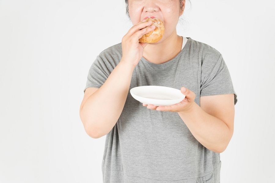 太った女性がシュークリームを食べる