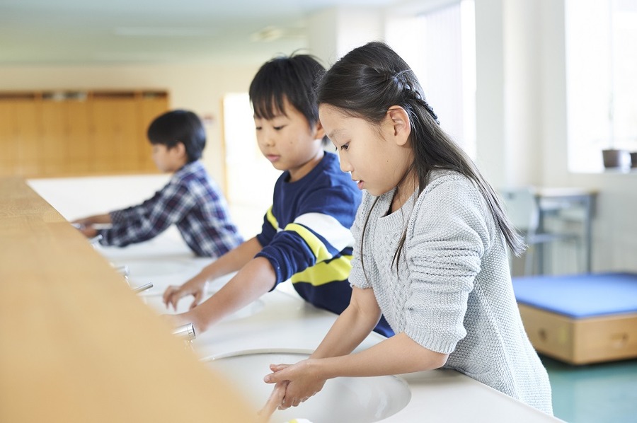 小学生が手を洗って、拭く