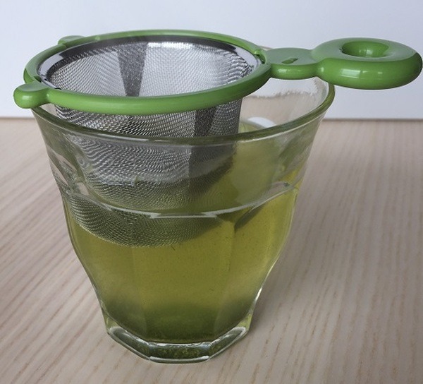 透明なコップで緑茶を淹れています