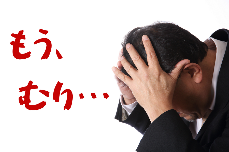頭をかかえる男性