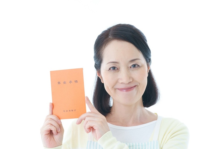 年金手帳を持って微笑む女性