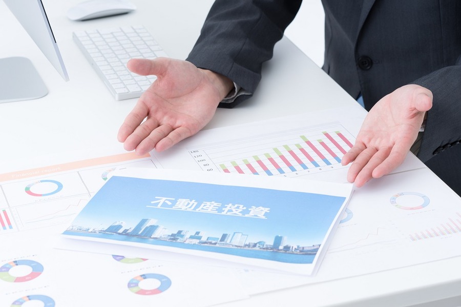 不動産投資を勧める男性の手