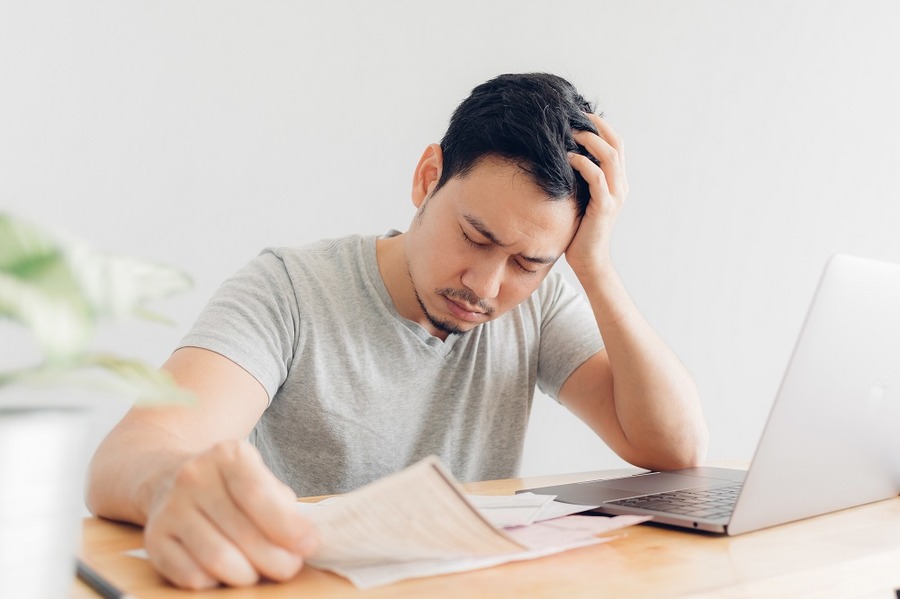 書類を見て悩む男性