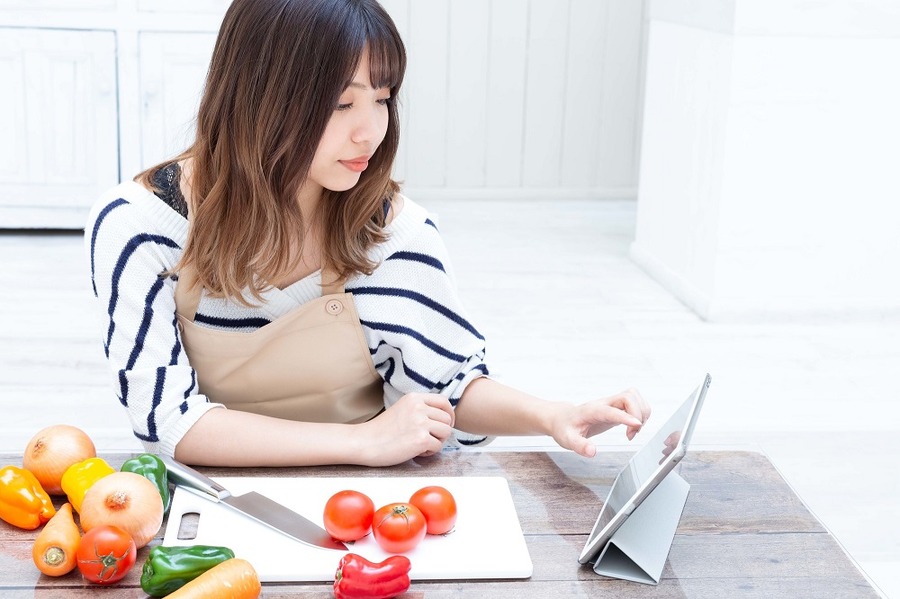 料理のレシピを探す女性