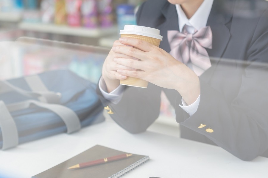 コンビニでコーヒーを飲む学生