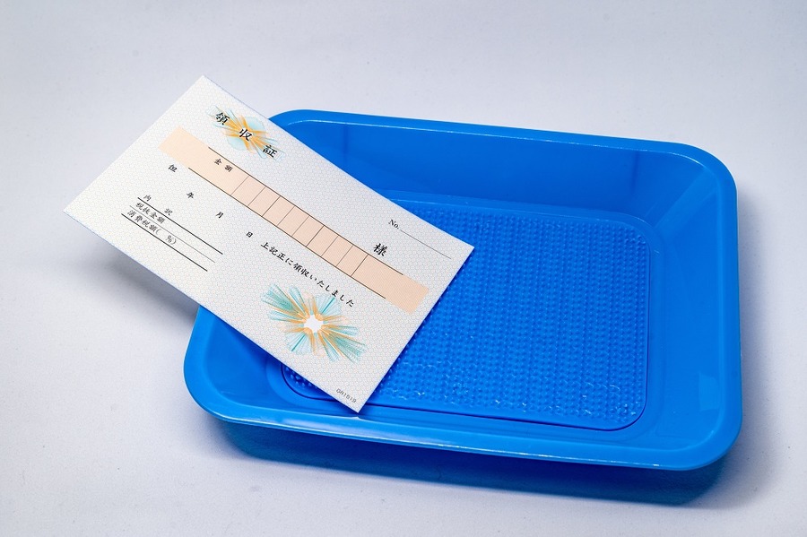 釣り銭トレイの上の領収書