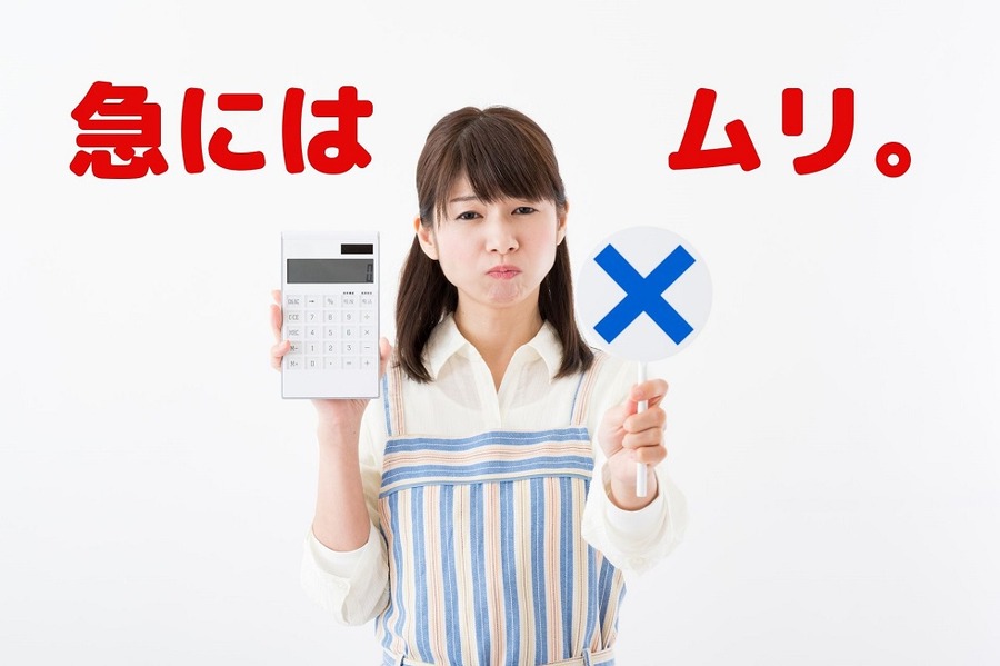 電卓とバツマークを持つ主婦