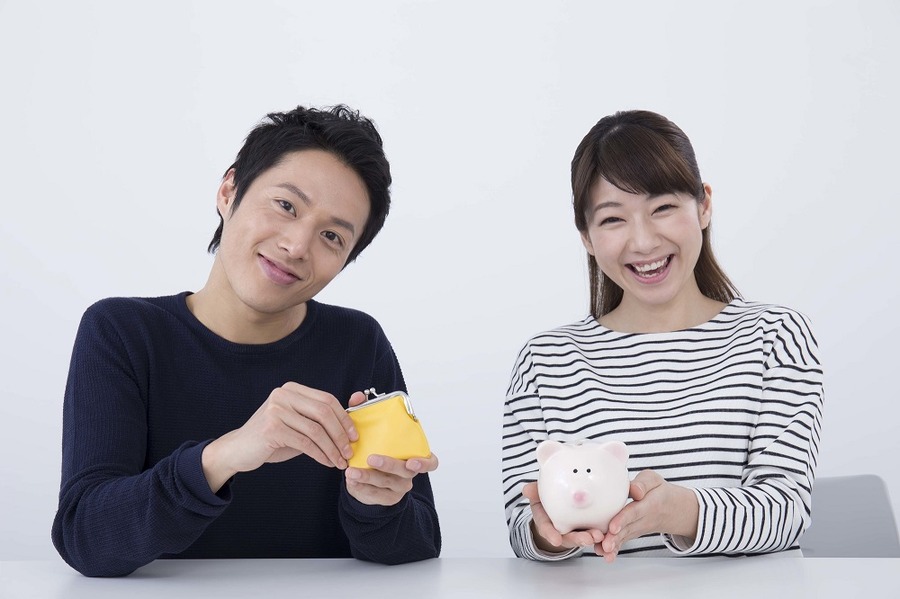 貯金箱と財布を持つ夫婦
