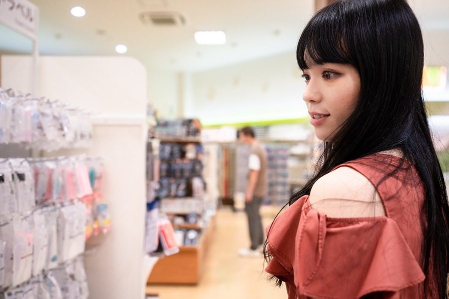 100均ショップで買い物をする女性