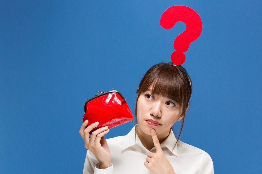 クエスチョンマークをつけた財布を持った女性