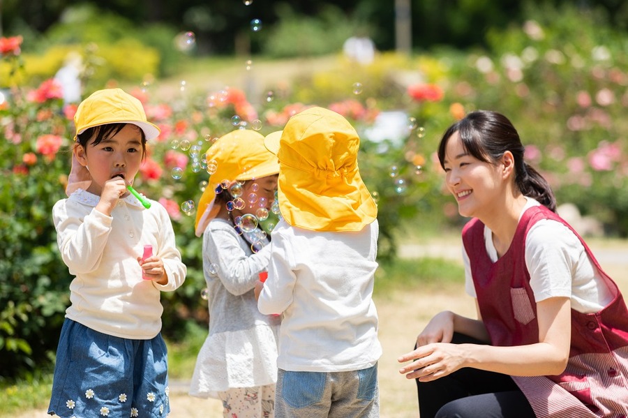 公園で遊ぶ保育士と園児たち