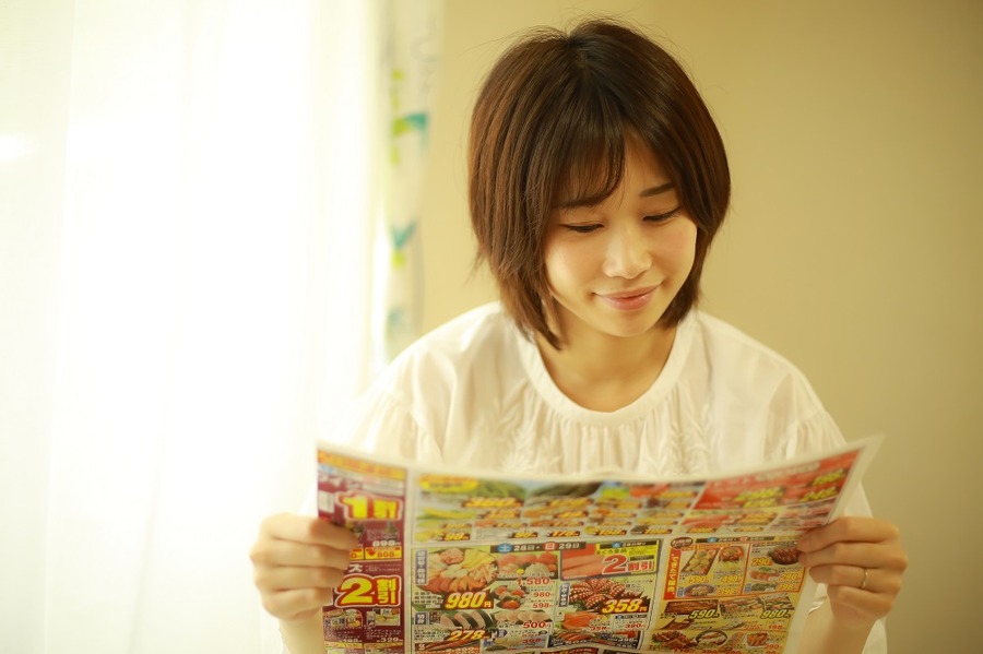 スーパートライアルのチラシをチェックする主婦