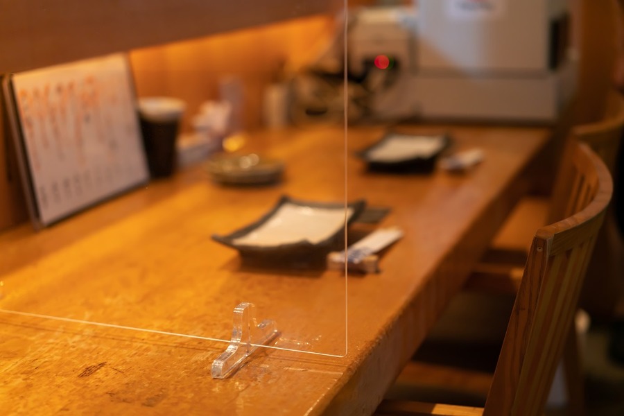 コロナ対策でアクリル板を設置した居酒屋