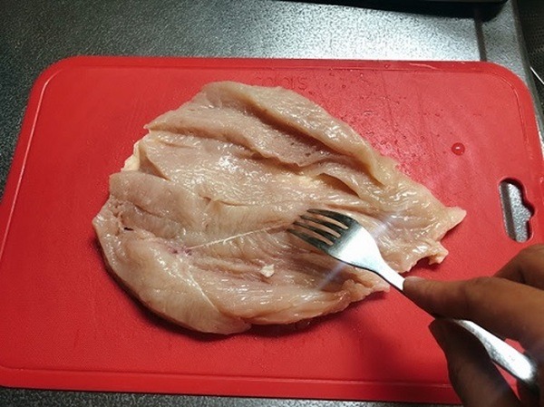 鶏むね肉をフォークで刺す