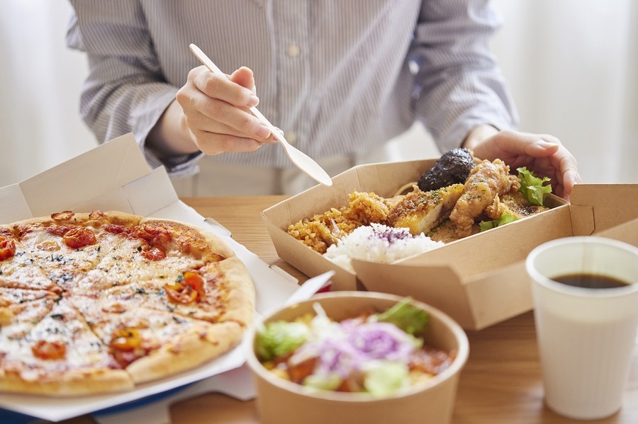 フードデリバリー食を食べる女性の手元