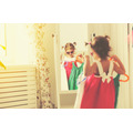 <p>little girl child looks into the mirror and choose dresses</p>