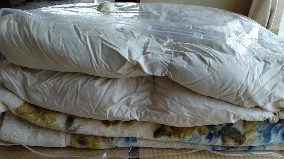 一人分のシングル掛け布団、敷き布団、毛布が一つの圧縮袋に一緒に収納